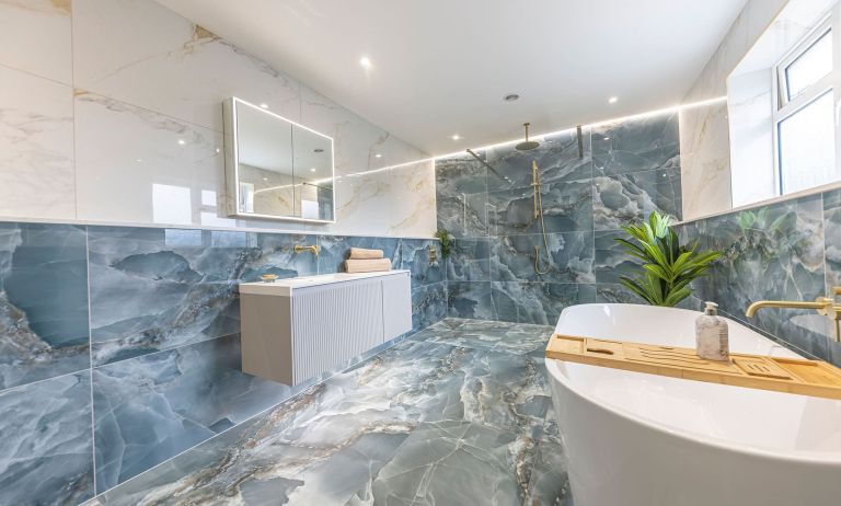 blue bathroom with blue tiles and gold brassware